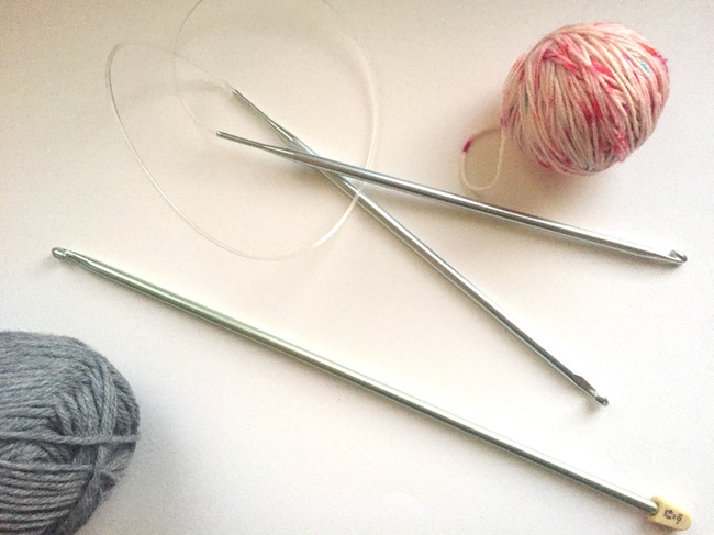 tunisian crochet hook and two small balls of yarn