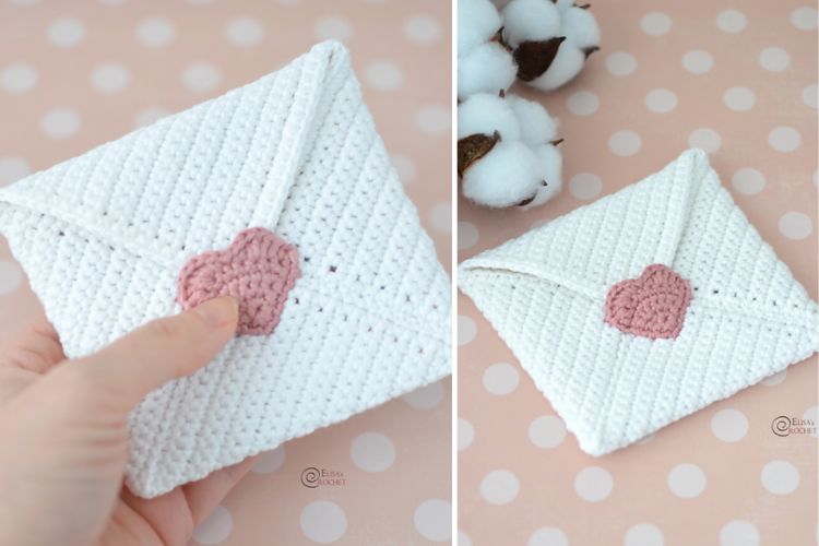 A hand holding a crochet heart on a white envelope.